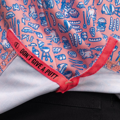 Interior detail of SWAG Golf Backyard BBQ Classic Polo featuring signature Don't Give A Putt embroidery tape in bold pink accent color and custom cookout-inspired pattern interior