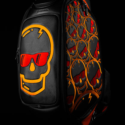 Swag x Vessel tour staff black golf bag with orange and red skull designs.