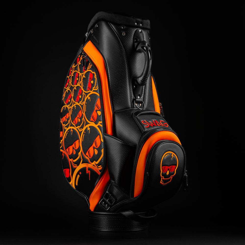 Swag x Vessel tour staff black golf bag with orange and red skull designs.