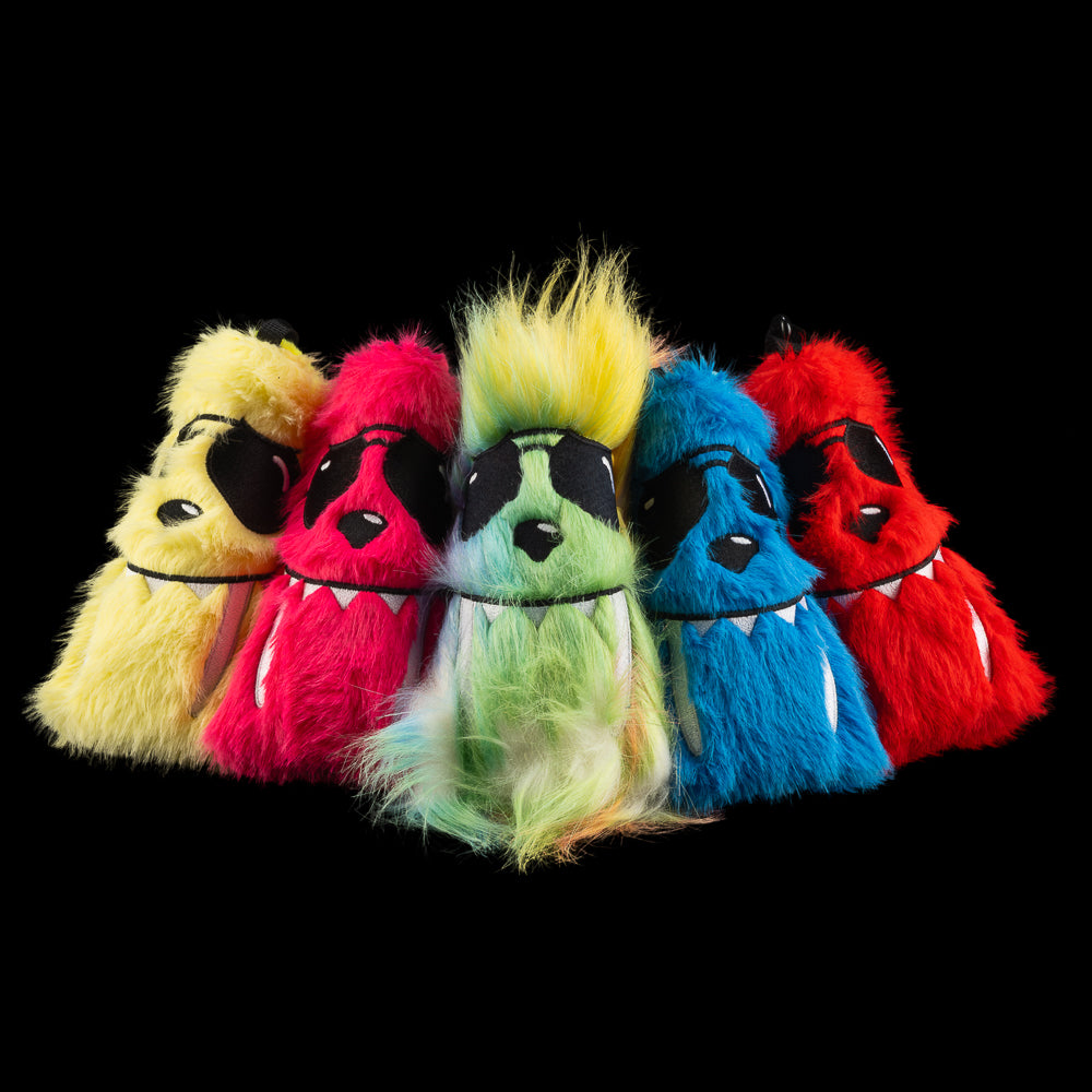 Group of five fuzzy SWAG Golf LaBooster blade putter covers in bright colors, each with a unique monster face and sunglasses.