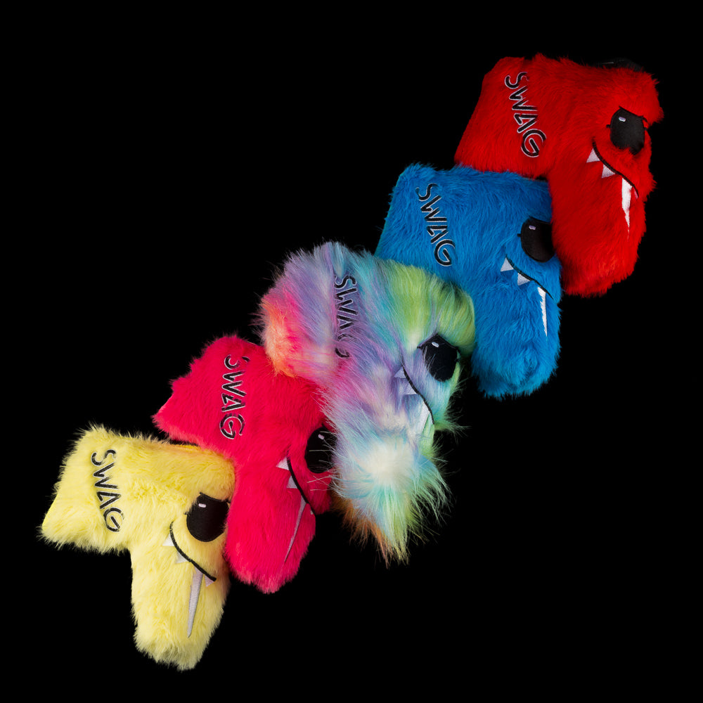 Five fuzzy SWAG Golf LaBooster blade putter covers arranged in a diagonal row, showing colorful fur and SWAG embroidery.