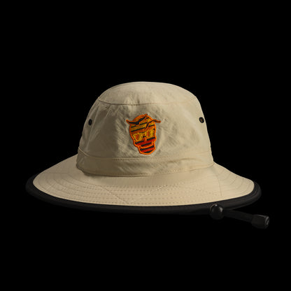 Beige bucket hat with a SWAG sunset skull logo on a black background