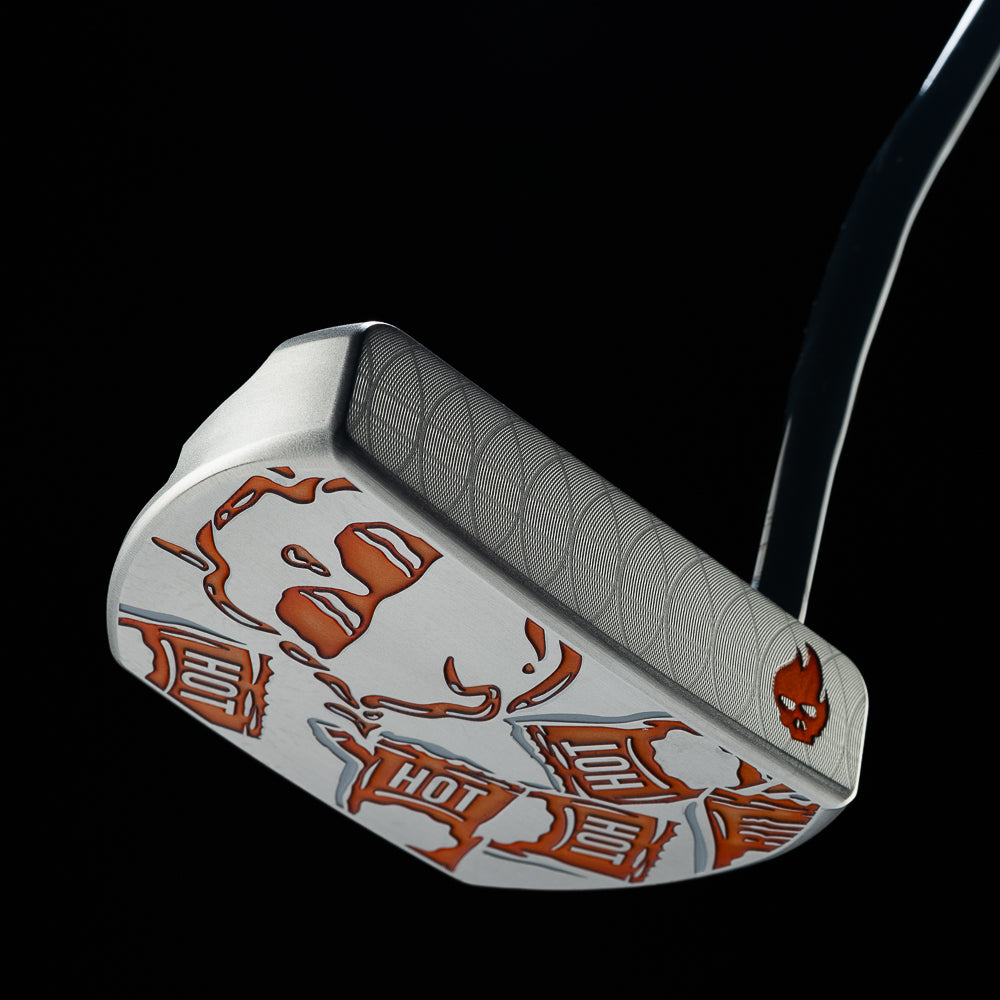 Angled view of the silver Hot Sauce BOSS 2.0 putter with orange sauce packet and skull graphics.