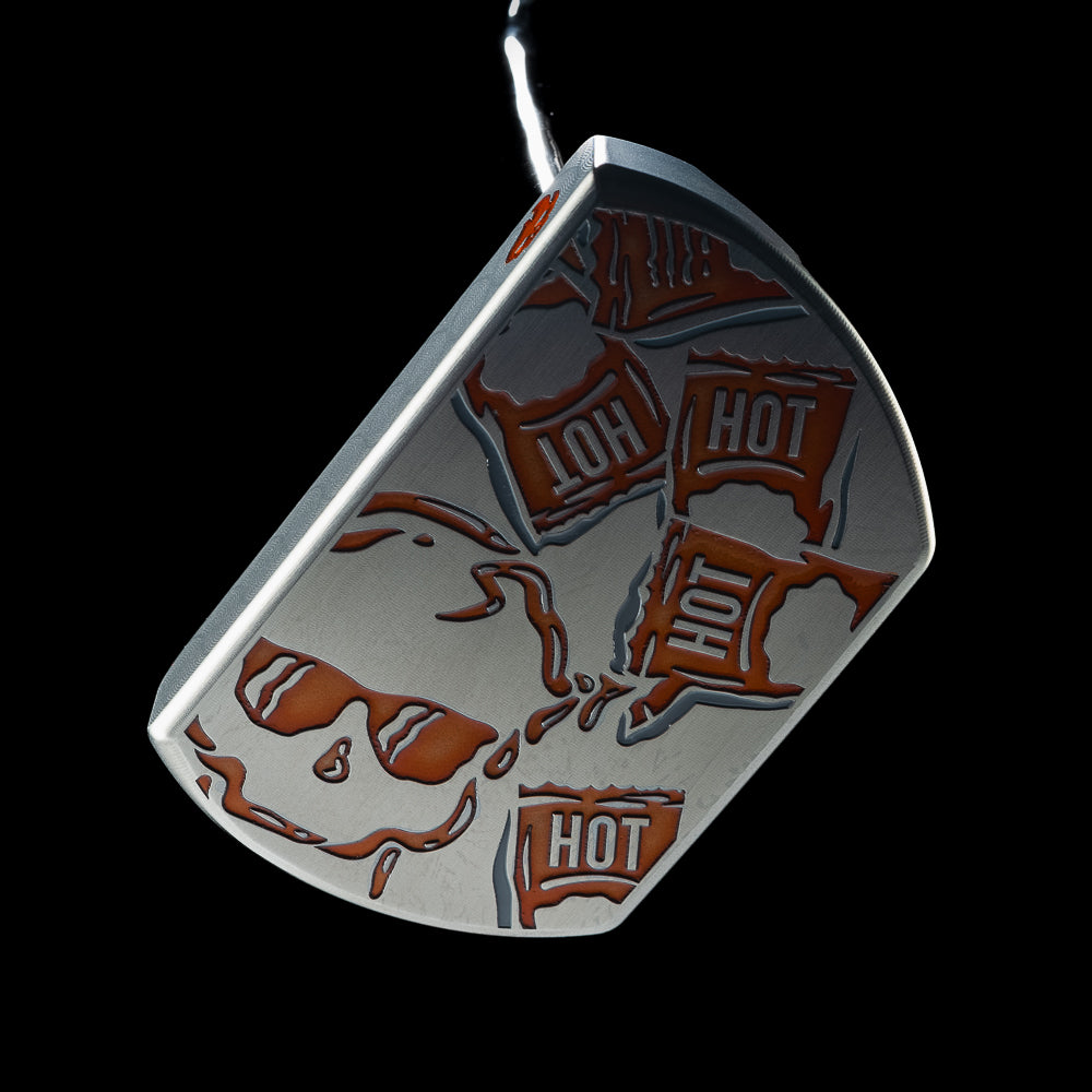 Close-up of orange Hot Sauce packet and skull graphics across the silver BOSS 2.0 putter head.