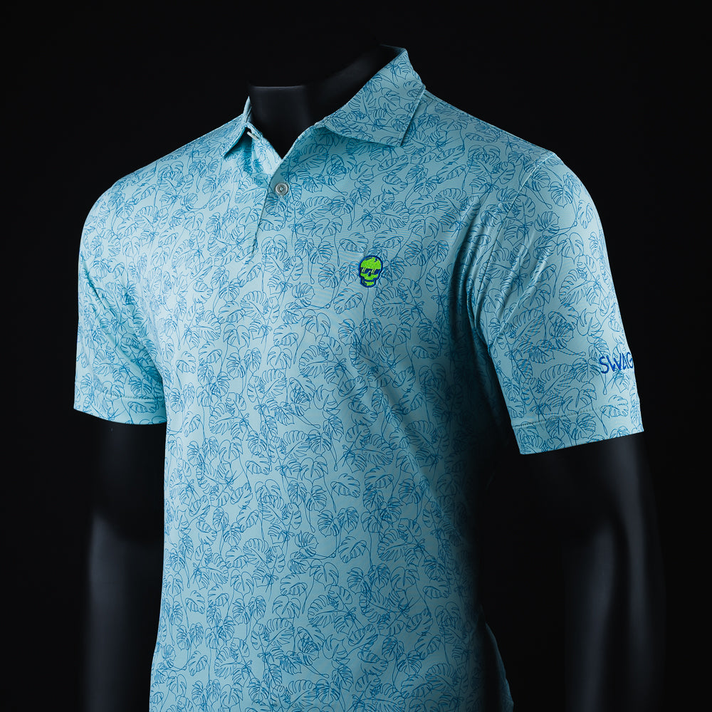 Swag x Peter Millar with an embroidered green Skull on a blue palm leaf print men's short sleeve golf polo shirt.