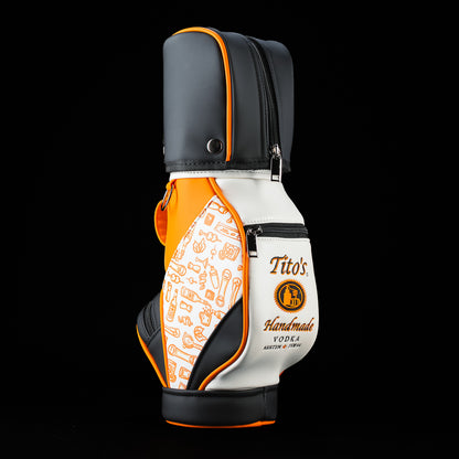 Side view of the SWAG Golf Tito's Bottle Caddy showing the black top cover, orange trim, and insulated bottle compartment.
