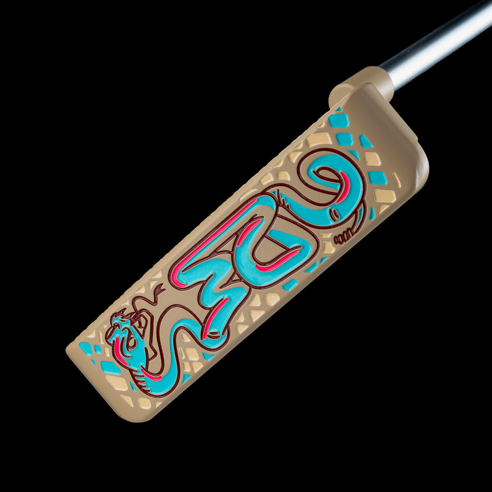 SWAG Golf Handsome One limited edition beige cerakote finish golf putter with a teal snake design and matching headcover.