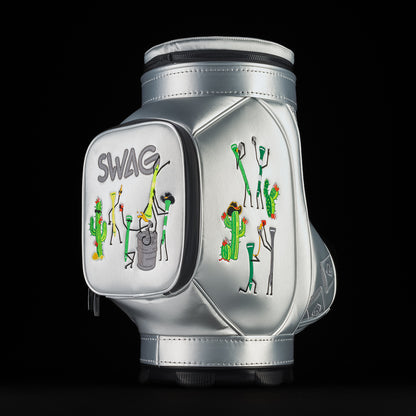 Angled side view of silver SWAG Golf Desert Tee Party Den Caddy highlighting side pocket embroidery with desert themed characters and golf tee graphics.
