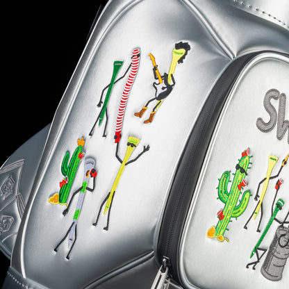 Close-up of side panel embroidery on silver SWAG Golf Desert Tee Party Den Caddy featuring whimsical desert characters and stylized golf tee figures.