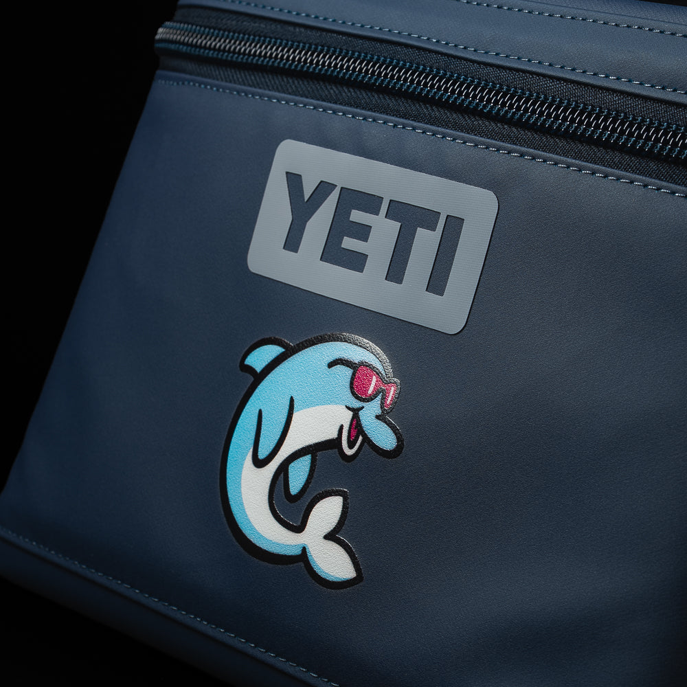 Close-up of the SWAG Golf x YETI Daytrip 9L insulated lunch box showing the YETI logo and exclusive Flipper mascot artwork.