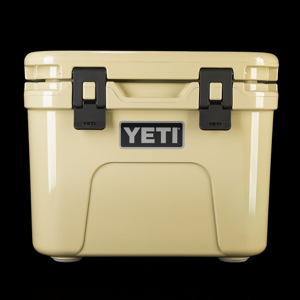 Front view of the SWAG Golf x YETI hard cooler with tan finish, black latches, and centered YETI logo.