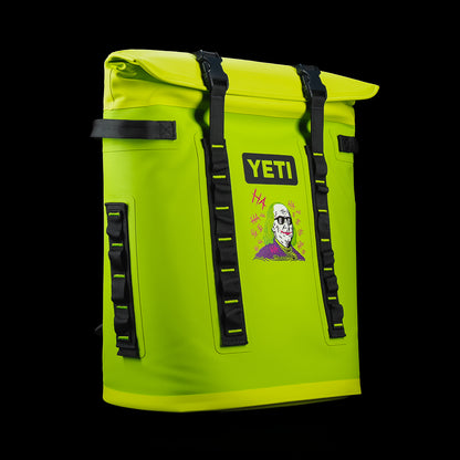 Angled front view of the SWAG Golf x YETI Hopper M20 backpack soft cooler with the Defaced Franklin graphic, clasp closure, and YETI branding.