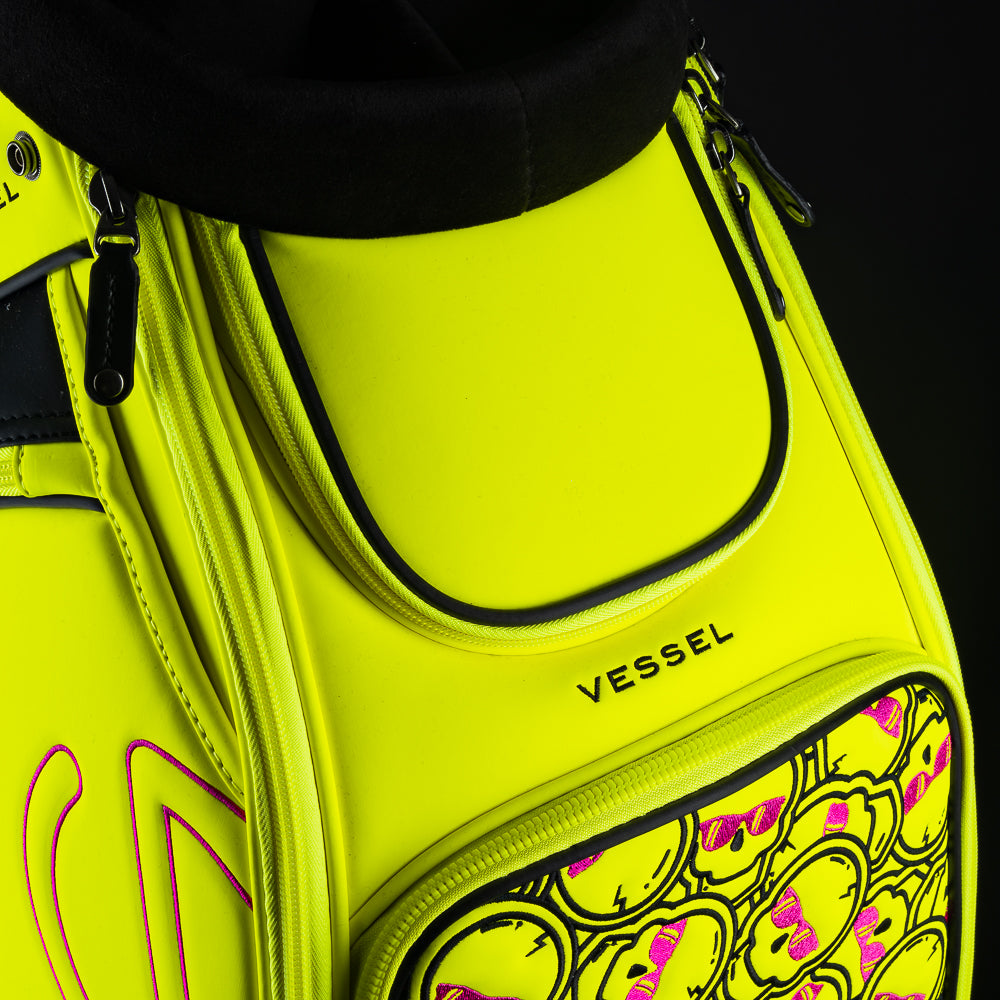 Swag x Vessel tour staff neon yellow golf club bag with stacked pink skulls.