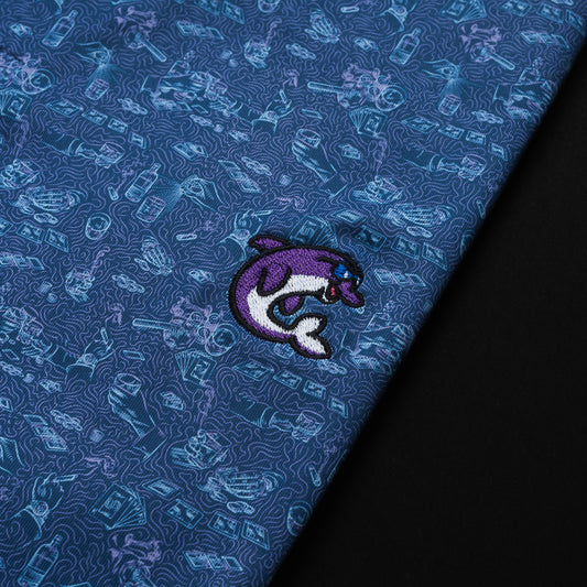 Swag x Peter Millar blue poker print men's short sleeve golf polo shirt with an embroidered purple dolphin on the left chest.