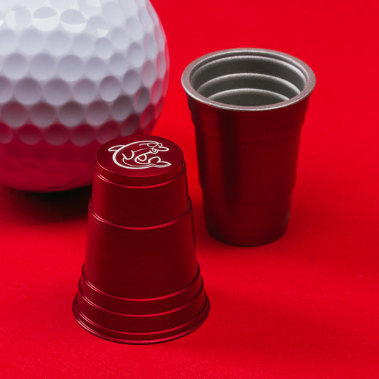 Red flip cup aluminum golf ball marker accessory with dolphin design made in the USA.