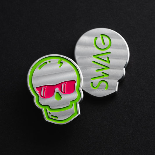 Swag skull stainless steel golf ball marker with green outline and pink sunglasses.