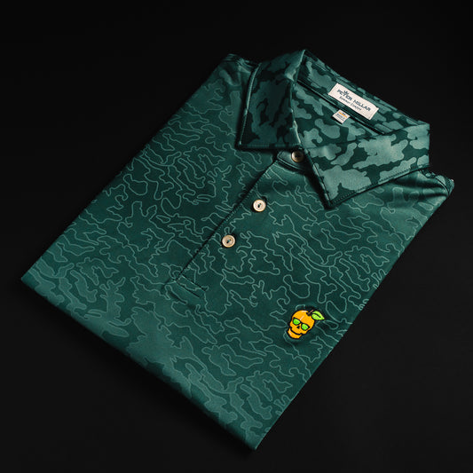 Swag x Peter Millar with an embroidered Peach on a green camo print men's short sleeve golf polo shirt.